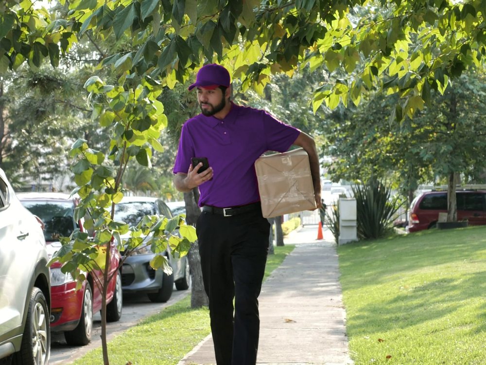 Courier walking to a delivery with a parcel