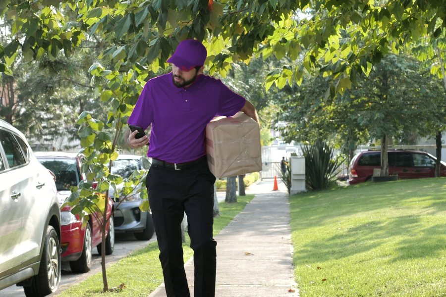Courier checking the delivery address on his phone