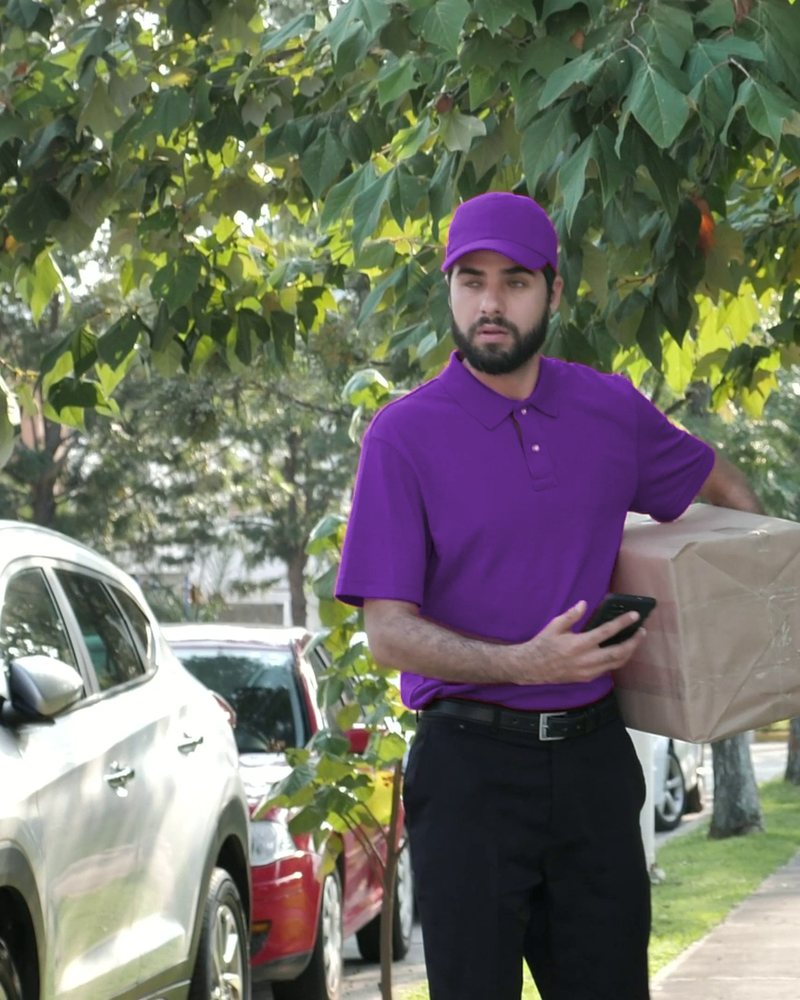 Courier on his way with a parcel and his phone