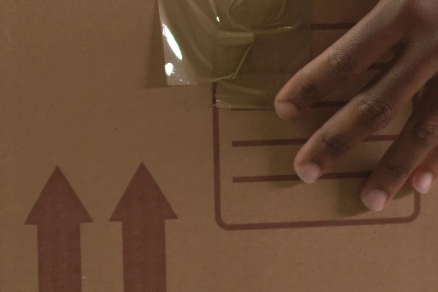 Hands sealing a parcel with packing tape