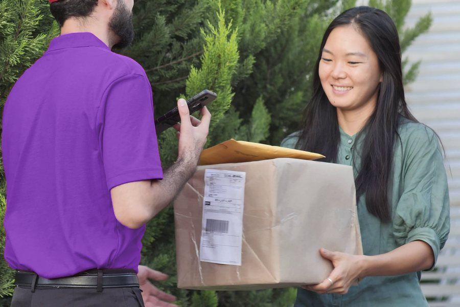Courier handing a parcel to a smiling customer